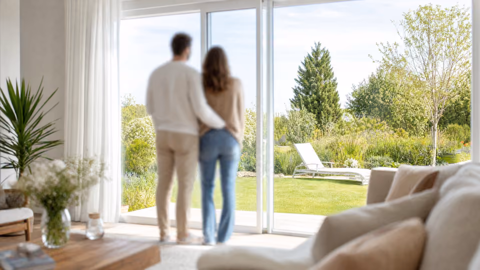 Couple de dos regardant le jardin depuis un intérieur chaleureux