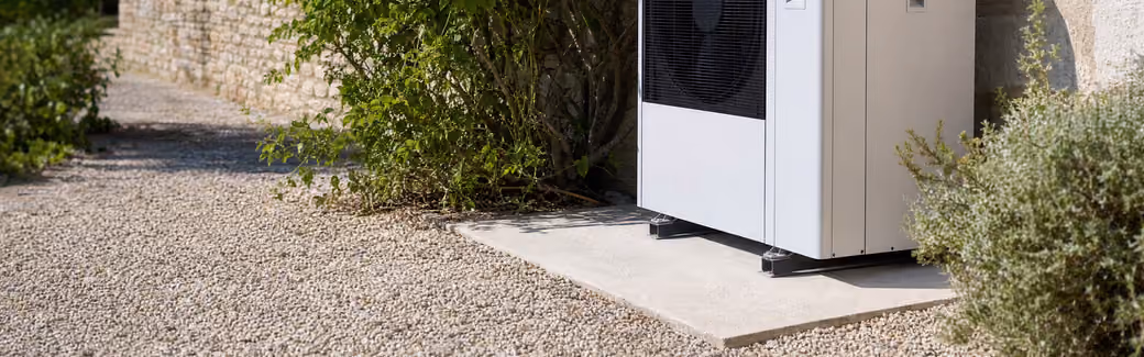 Pompe à chaleur air/eau installée contre un mur en pierre