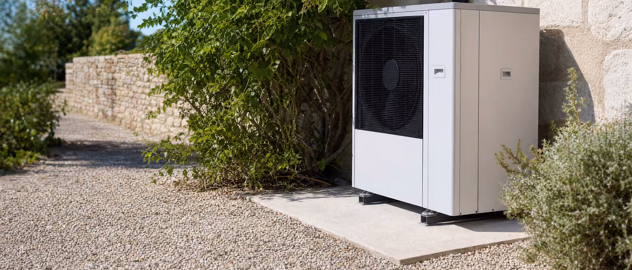 Pompe à chaleur air/eau installée contre un mur en pierre