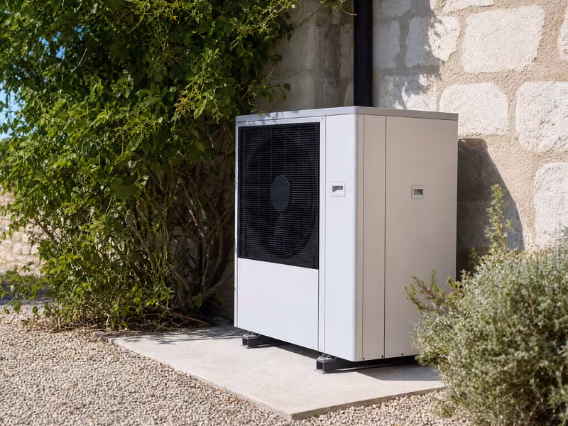 Pompe à chaleur air/eau installée contre un mur en pierre
